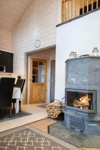 a fireplace in a patio with a table and chairs at Northern Lights Lodge in Kittilä