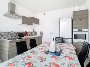 a kitchen with a table with a flower table cloth on it at Le refuge de Gavrelle - Maison 6 lits, Wifi in Gavrelle