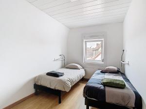 two beds in a room with white walls and a window at Le refuge de Gavrelle - Maison 6 lits, Wifi in Gavrelle