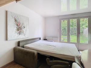 a bedroom with a bed and a table and window at Le jardin de Gavrelle, Maison 4 lits, Wifi, jardin in Gavrelle
