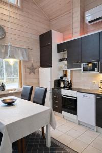 a kitchen with a table with chairs and a table and a kitchen with a table at Northern Lights Lodge in Kittilä