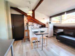 a kitchen and living room with a table and a couch at Le studio du centre in Gap