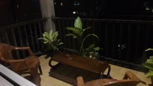 a balcony with chairs and a bench and plants at New Rani Inn in Negombo