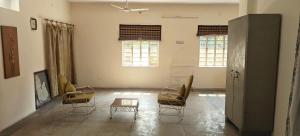 a room with chairs and a table and two windows at Dalpat singh in Jaipur