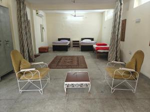a room with two beds and two chairs and a table at Dalpat singh in Jaipur