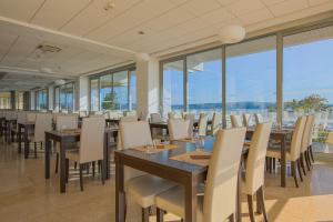 a dining room with tables and chairs and windows at Paviljoni Omorika in Crikvenica
