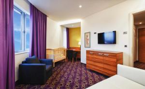 Televízia a/alebo spoločenská miestnosť v ubytovaní Hotel Sport