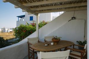 a wooden table and chairs sitting on a balcony at Anna's House in Koufonisia