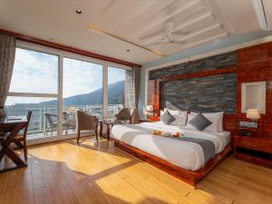 a bedroom with a large bed and a large window at Moustache Select Mcleodganj in Dharamshala