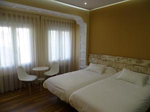 1 dormitorio con 1 cama, mesa y sillas en Urban Burgos, en Burgos