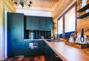 a kitchen with green cabinets and a wooden counter top at Chata Czego Dusza Pragnie in Zachełmie