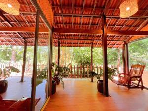 a covered porch with chairs and potted plants on it at An Tiên Ecolodge in Tân Phú +16 photos