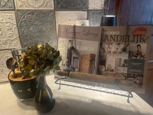a vase with flowers on a counter with books at Chassepierre's Soul in Chassepierre