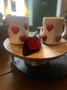 two coffee cups with hearts on them on a wooden plate at Chassepierre's Soul in Chassepierre
