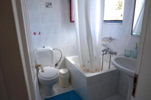 a white bathroom with a toilet and a sink at Cybele Apartments in Makry Gialos