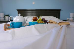 a tray of fruit and a tea set on a bed at Cybele Apartments in Makry Gialos