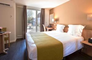 a hotel room with a large bed and a balcony at Flanders Hotel in Bruges