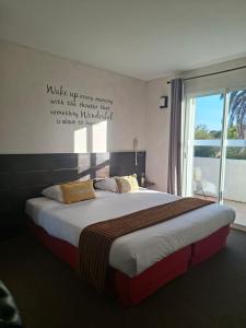 a bedroom with a large bed with a window at Logis Hôtel Synaya in Sanary-sur-Mer +51 photos