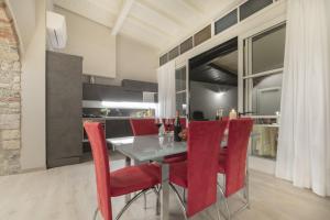 a dining room with a table and red chairs at Suite del Pirata in Gargnano