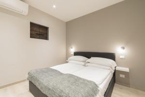 a bedroom with a large bed with white sheets at Suite del Pirata in Gargnano