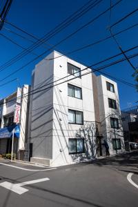 a white building on the corner of a street at Mi-Hotel Nakano- Shinjuku Direct 中野南台 in Tokyo