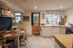 a kitchen and dining room with a table and chairs at The Old Post Box in Holton