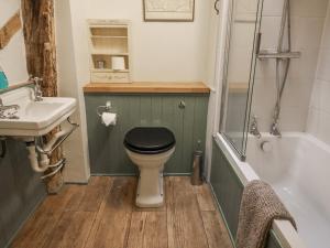 a bathroom with a black toilet and a sink at The Old Post Box in Holton +22 photos