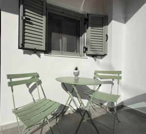 two green chairs and a table and a table and chairs at Spitaki in Kremasti