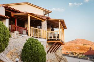 a house with a balcony on a mountain at Limnos View Apartments in Agios Ioannis Kaspaka