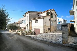 an empty street with a white house with a garage at AP Silvija in Zadar