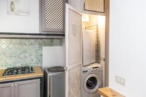 a kitchen with a refrigerator and a washer and dryer at Casa Ale in centro in Santa Maria Navarrese