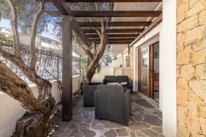 an outdoor patio with chairs and a tree at Casa Ale in centro in Santa Maria Navarrese