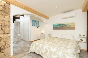 a bedroom with a bed and a stone wall at Casa Ale in centro in Santa Maria Navarrese