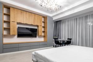 a bedroom with a bed and a tv and a table at Velora Apartments in Năvodari