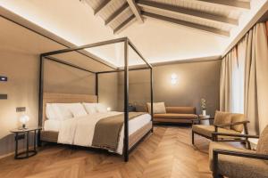 a bedroom with a bed and a couch and a chair at Lenel Boutique Room - La Locanda in Brescia