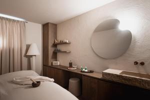 a bathroom with a bed and a sink and a mirror at stieg'nhaus Design Boutique Hotel in Mühlbach am Hochkönig +106 photos