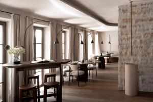 a restaurant with tables and chairs and windows at stieg'nhaus Design Boutique Hotel in Mühlbach am Hochkönig
