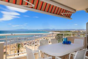 a balcony with a table and chairs and the beach at UHC SANTILLANA FAMILY COMPLEX in Salou