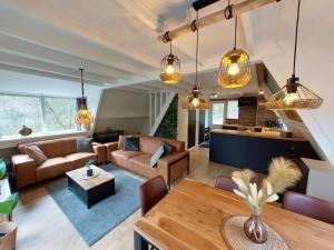 a living room with a couch and a table at Chalet Het Hulstje 2 in Durbuy