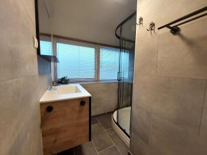 a bathroom with a sink and a shower at Chalet Het Hulstje 2 in Durbuy