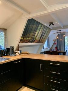 a kitchen with a counter top and a window at Chalet Het Hulstje 2 in Durbuy