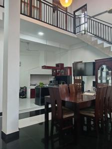 a dining room with a table and chairs and a staircase at Ibis in Udawalawe