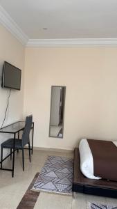 a bedroom with a bed and a desk and a television at AMWAJ HOTEL in El Jadida