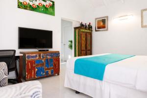 a bedroom with a bed and a flat screen tv at Casalina Garden 2 blocks to Palm Beach & Kitesurfing school in Palm-Eagle Beach +24 photos