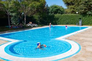 a young child swimming in a swimming pool at Camping Villaggio Il Pilone in Rosa Marina