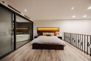 a bedroom with a large bed and a walk in shower at PentStudio Duplex Apartment in Hanoi