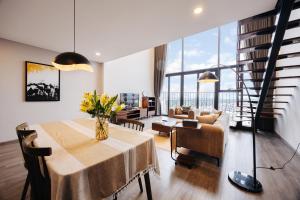 a dining room with a table and a living room with a view at PentStudio Duplex Apartment in Hanoi