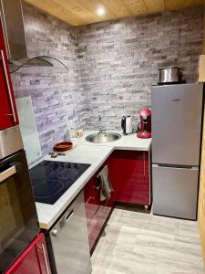 a kitchen with a sink and a refrigerator at Chalet cocody jacuzz in Jausiers