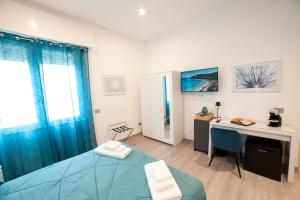 a bedroom with a blue bed and a desk and a deskablish at Mhometredici Guest House - Camere moderne a Sestu vicino aeroporto Cagliari e Policlinico in Sestu