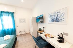 a bedroom with a desk and a blue chair in a room at Mhometredici Guest House - Camere moderne a Sestu vicino aeroporto Cagliari e Policlinico in Sestu
